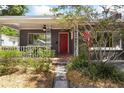 Inviting covered front porch with decorative railings and a vibrant red front door at 1222 E Powhatan Ave, Tampa, FL 33604