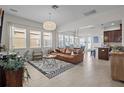 Open concept living room with a large leather couch, modern rug, and ample natural light at 14493 Promenade Pkwy, Odessa, FL 33556