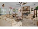 Cozy living room featuring a brick fireplace, plush seating, and bright natural light at 15053 Peace Blvd, Spring Hill, FL 34610