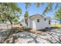 Well-maintained single-story home featuring a light-colored exterior, fenced yard, and concrete patio space at 1540 7Th E Ave, Bradenton, FL 34208
