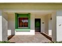 Inviting front porch with a green front door, a brick-laid porch floor, and green trim window at 2557 Laurelwood Dr # 10E, Clearwater, FL 33763
