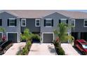 A row of well-maintained townhomes with gray exteriors and manicured landscaping at 32573 Turtle Grace Loop, Wesley Chapel, FL 33545