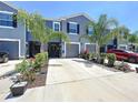 Attractive townhome with well-maintained landscaping, driveway, and charming curb appeal at 32573 Turtle Grace Loop, Wesley Chapel, FL 33545