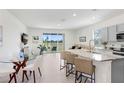 Open-concept kitchen and dining area featuring an island with chairs and views of the backyard at 32978 Tulip Petal Ln, Wesley Chapel, FL 33545