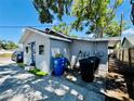 Rear exterior view showing the house and trash receptacles on the concrete patio at 3498 13Th S Ave, St Petersburg, FL 33711
