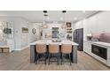 Modern kitchen features a spacious island with seating, pendant lighting, and sleek white cabinetry at 4108 Mellon Dr, Odessa, FL 33556