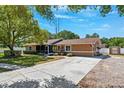 Inviting one-story home showcasing a spacious driveway and an expansive, well-maintained front yard at 506 Spring Tree Ct, Tarpon Springs, FL 34689