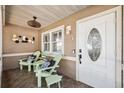 Cozy front porch featuring comfortable seating, stylish decor, and a welcoming entrance with an oval glass door at 506 Spring Tree Ct, Tarpon Springs, FL 34689