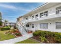 Inviting condo exterior with clean white facade, landscaped walkway, and stairs to upper-level units at 5915 18Th N St # 11, St Petersburg, FL 33714