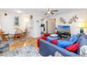Cozy living room with ceiling fan, view to dining, wood floors, and comfortable seating arrangement at 5915 18Th N St # 11, St Petersburg, FL 33714