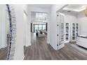 Bright entryway with hardwood floors, transom window, and view of living room at 5958 Talon Preserve Dr, Nokomis, FL 34275