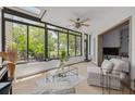 Light-filled sunroom with expansive windows, tile floors, skylight, and neutral decor, creating a relaxing atmosphere at 60 Woodridge Cir, Oldsmar, FL 34677