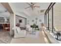 Bright sunroom with tile flooring, comfortable seating, piano, and large windows offering serene outdoor views at 60 Woodridge Cir, Oldsmar, FL 34677