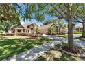 Beautiful home with lush green lawn, mature trees and brick paver driveway at 607 Vintage Way, Brandon, FL 33511
