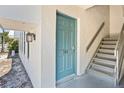 Unit 702 features a quaint entrance with a light blue door and gray stairs leading to upper level at 716 Lyndhurst St # 702, Dunedin, FL 34698