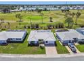 Aerial view of a single-story home showcasing a tile roof, proximity to golf course, and manicured landscaping at 10036 40Th N St # 3, Pinellas Park, FL 33782