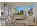 Cozy front porch with ample seating, providing a welcoming atmosphere and views of the surrounding greenery at 147 & 139 Edgewater Dr, Dunedin, FL 34698