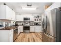 Bright kitchen featuring stainless steel appliances, white cabinetry, and butcher block countertops at 186 Grand Ave, Brooksville, FL 34604