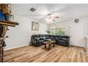 Cozy living room featuring hardwood floors, a ceiling fan, and a comfortable black leather sofa at 186 Grand Ave, Brooksville, FL 34604