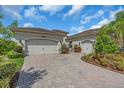 Spacious three car garage with paver driveway and meticulously maintained landscaping at 2165 Hollow Forest Ct, Wesley Chapel, FL 33543