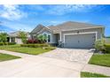 Attractive single-story home with a well-kept lawn, colorful flowers, and a paved driveway at 2511 Early Dawn Ct, Valrico, FL 33594