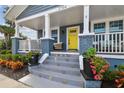 Close-up of front steps with colorful tile details, potted plants, and a bright yellow door at 2704 W Main St, Tampa, FL 33607