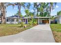 A cozy home with a long driveway and carport, enhanced by lush tropical landscaping at 2909 60Th N Ave, St Petersburg, FL 33714