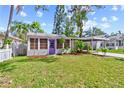 Quaint home with beautiful, mature landscaping, a purple door, and a well-kept lawn at 2909 60Th N Ave, St Petersburg, FL 33714