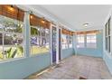 Enclosed front porch with tile flooring, string lights, and lots of natural light at 2909 60Th N Ave, St Petersburg, FL 33714