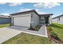 Exterior shot of a single-Gathering home with a two-car garage, front walkway, and landscaped flower beds at 3590 Moscato Dr, Brooksville, FL 34602