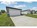 Exterior view of a home's garage, showcasing the driveway, lawn, and surrounding neighborhood homes at 3590 Moscato Dr, Brooksville, FL 34602