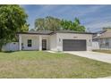 The front of a modern one-story home with a gray garage door and well-kept lawn at 4021 Ohio Ave, Tampa, FL 33616