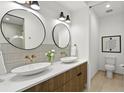Modern bathroom with dual sinks, round mirrors, and stylish fixtures at 409 E Oak Ave # 9, Tampa, FL 33602