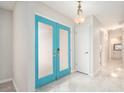 Bright foyer featuring double doors, neutral walls, tiled floors, and modern light fixture at 4120 Marine Pkwy, New Port Richey, FL 34652