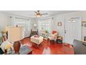 Bright living room with red wood floors and comfortable seating arrangement, illuminated by natural light at 6556 S West Shore Cir, Tampa, FL 33616