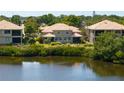 A peaceful backyard with a serene lake view surrounded by lush greenery and well-maintained landscaping at 7657 Caponata Blvd, Seminole, FL 33777
