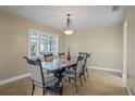 Traditional dining room with a unique tile-top table set with seating for six under elegant chandelier at 8763 Matthew St, Seminole, FL 33772