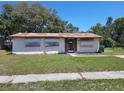 A single-story home showing boarded up windows and front yard at 9355 Pinero St, Spring Hill, FL 34608