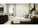 Serene bedroom featuring neutral tones, soft textures, a comfortable bed, and a window with natural light at 10258 Gentle Rain Dr, Land O Lakes, FL 34638