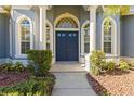 Elegant double front doors with arched transom window and manicured landscaping at 10726 Miracle Ln, New Port Richey, FL 34654
