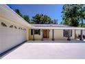 Charming home featuring a covered front porch, attached garage, and ample parking space at 1120 Country Ln, Lutz, FL 33558