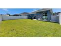 Spacious backyard featuring lush green grass and a covered patio, perfect for outdoor entertaining at 12123 Ledbury Commons Dr, Gibsonton, FL 33534