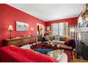 Inviting living room features red walls, classic furnishings, and ample natural light, creating a warm and cozy atmosphere at 1603 S Arrawana Ave, Tampa, FL 33629