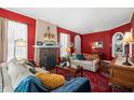 Comfortable living room with red walls, fireplace, vintage rug and neutral furniture at 1603 S Arrawana Ave, Tampa, FL 33629