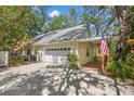 Charming home featuring a two-car garage and a welcoming porch with a patriotic American flag displayed at 187 Sage Cir, Crystal Beach, FL 34681