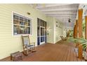 Relax on this spacious porch, complete with rocking chair, wooden floors, and a ceiling fan at 187 Sage Cir, Crystal Beach, FL 34681