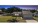 Charming single-story home with a well-maintained lawn and attached two-car garage at dusk at 1985 Hastings Dr, Clearwater, FL 33763