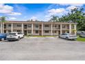 Apartment building featuring parking spots, two levels, and palm trees providing shade at 2275 62Nd N Ave # 5202, St Petersburg, FL 33702