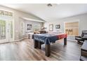 Open living space with foosball table, pool table covered with an American flag, and wood-look floors at 25324 Lexington Oaks Blvd, Wesley Chapel, FL 33544