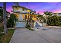 Beautiful multi-story home with lush tropical landscaping, front facing garages, and a grand entrance at 294 Kentucky Ave, Crystal Beach, FL 34681